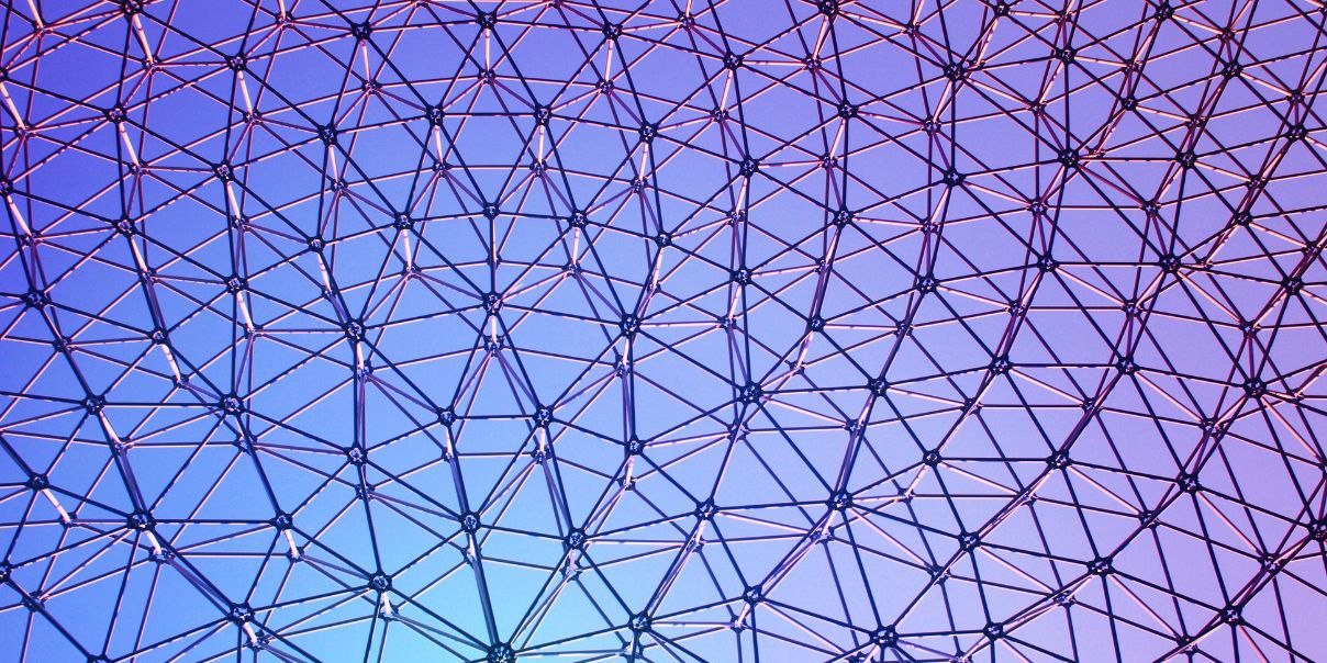 Geodesic dome structure against a gradient blue and purple sky