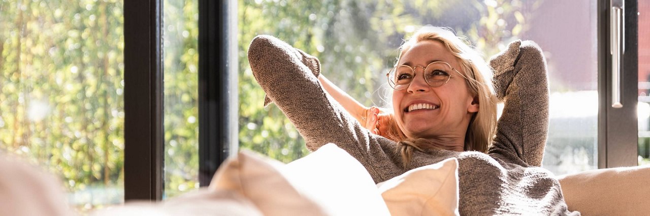 lady wearing glasses sitting on sofa and smilling