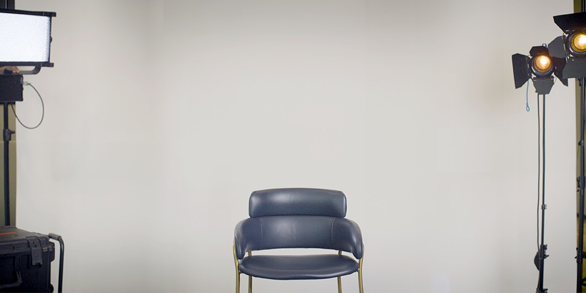 A chair in a room with cameras and screen around it