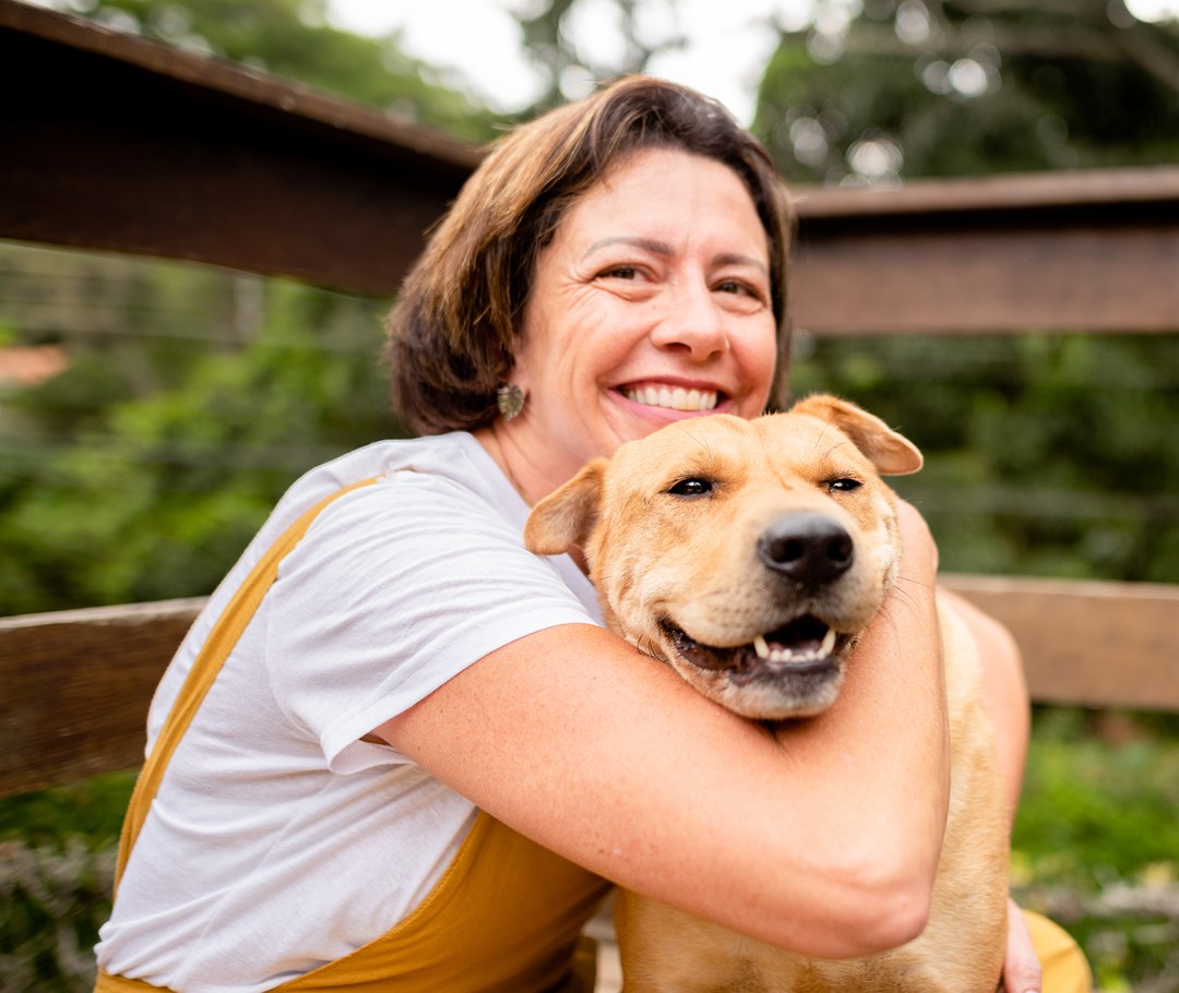 Woman smiling with a dog in her arms