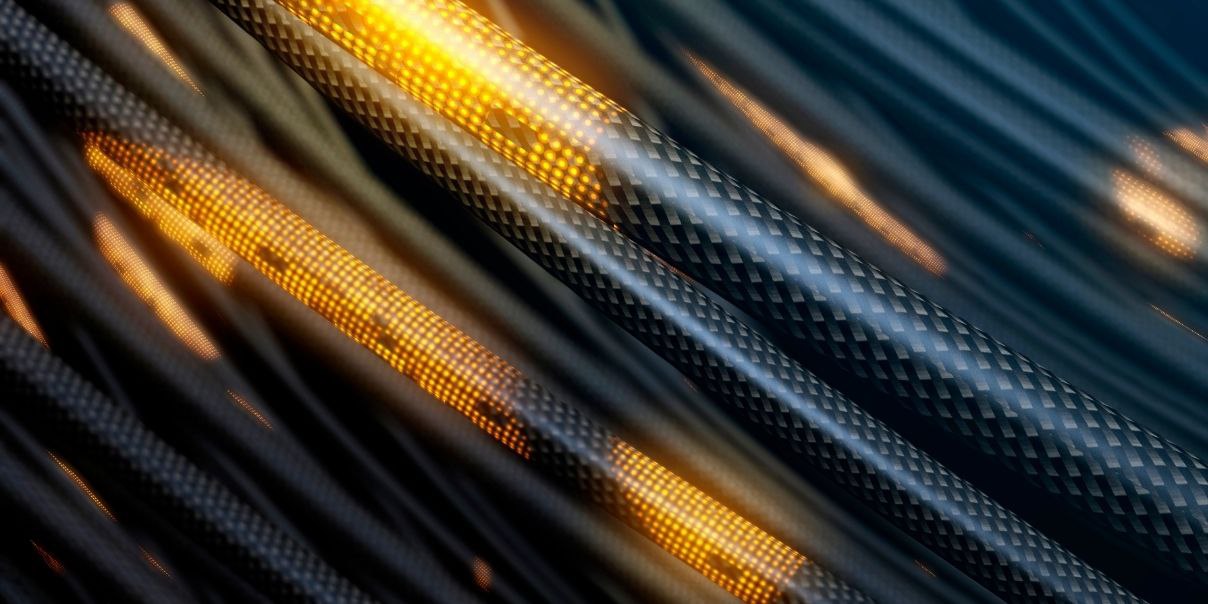 A stylized or artistic close-up of braided cables or wires, with metallic textures and dramatic lighting in orange and yellow tones.