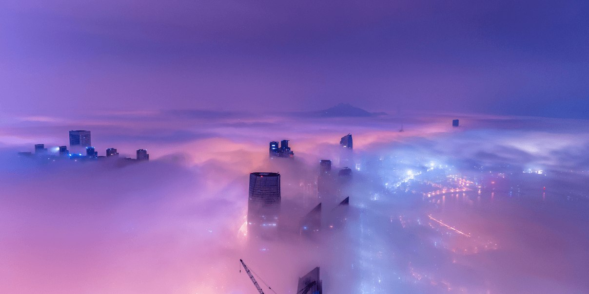 A nighttime cityscape in the clouds, shrouded in fog, creating a mystical and ethereal atmosphere.