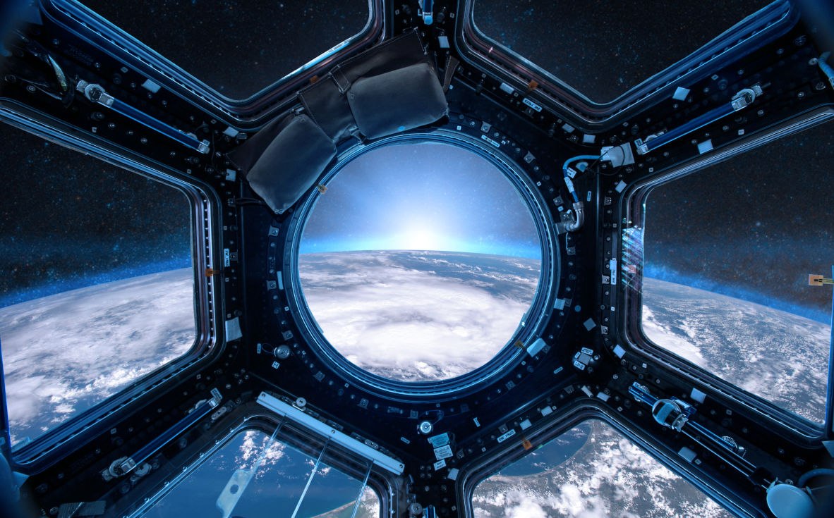 View from a porthole of space station on the Earth background. Elements of this image furnished by NASA.