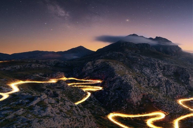 illuminated zigzag road within mountain