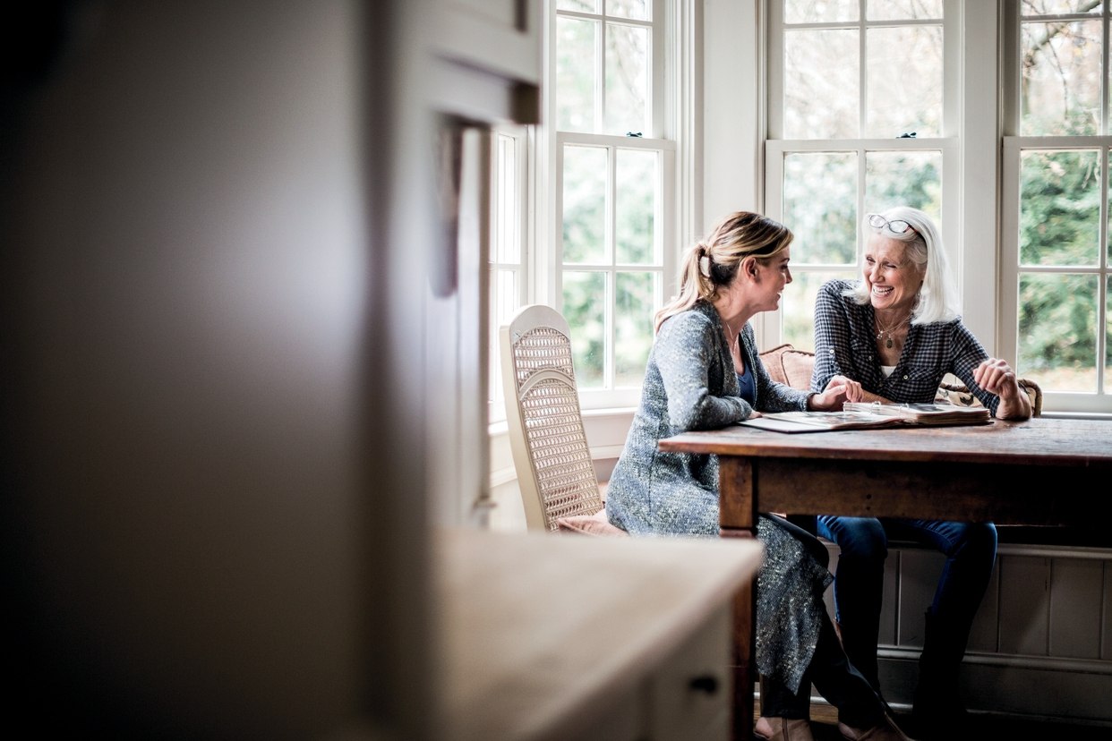 2 women talking to each other sitting on chair