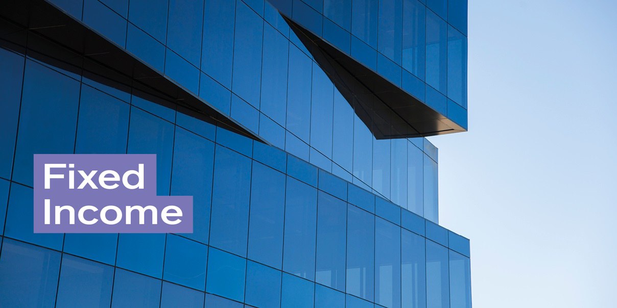 A sleek, modern building with a striking glass facade that mirrors the blue sky