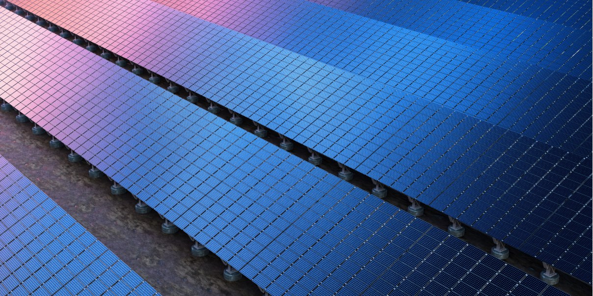 Rows of blue and purple solar panels arranged in parallel lines, mounted on a flat surface, capturing sunlight for renewable energy generation.