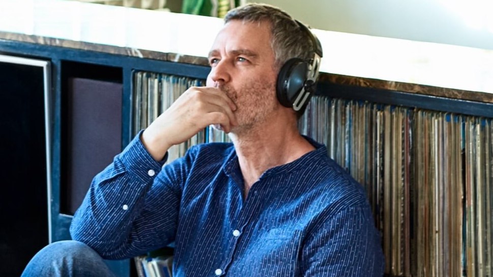 Man sitting wearing headphones while listening to records