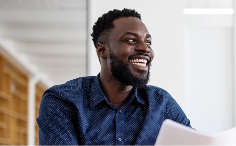 man with black beard smilling hold some papers