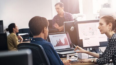 people in office discussing on monitor screen with graph