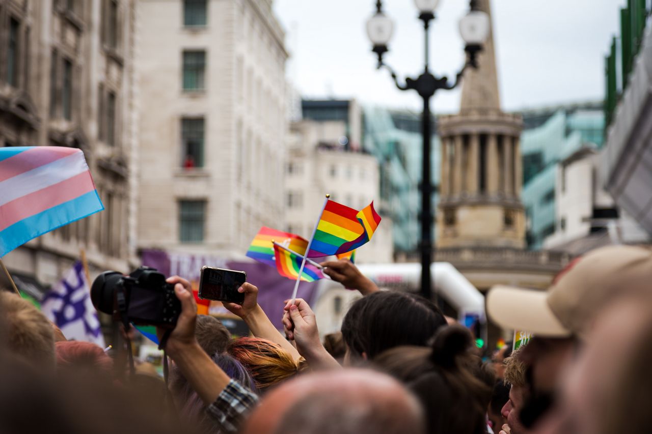 Color image depicting crowds of people celebrating at the London Gay Pride parade in the city centre. People are dressed in colorful outfits, and the rainbow flag - the symbol of the LGBTQ community - is prevalent. Regent Street is thronged with people at this celebratory event. Room for copy space.