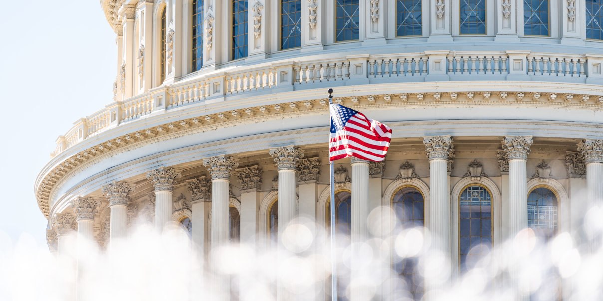 US Congress dome closeup with background of water fountain splashing, American flag waving in Washington DC, USA closeup on Capital capitol hill, columns, pillars