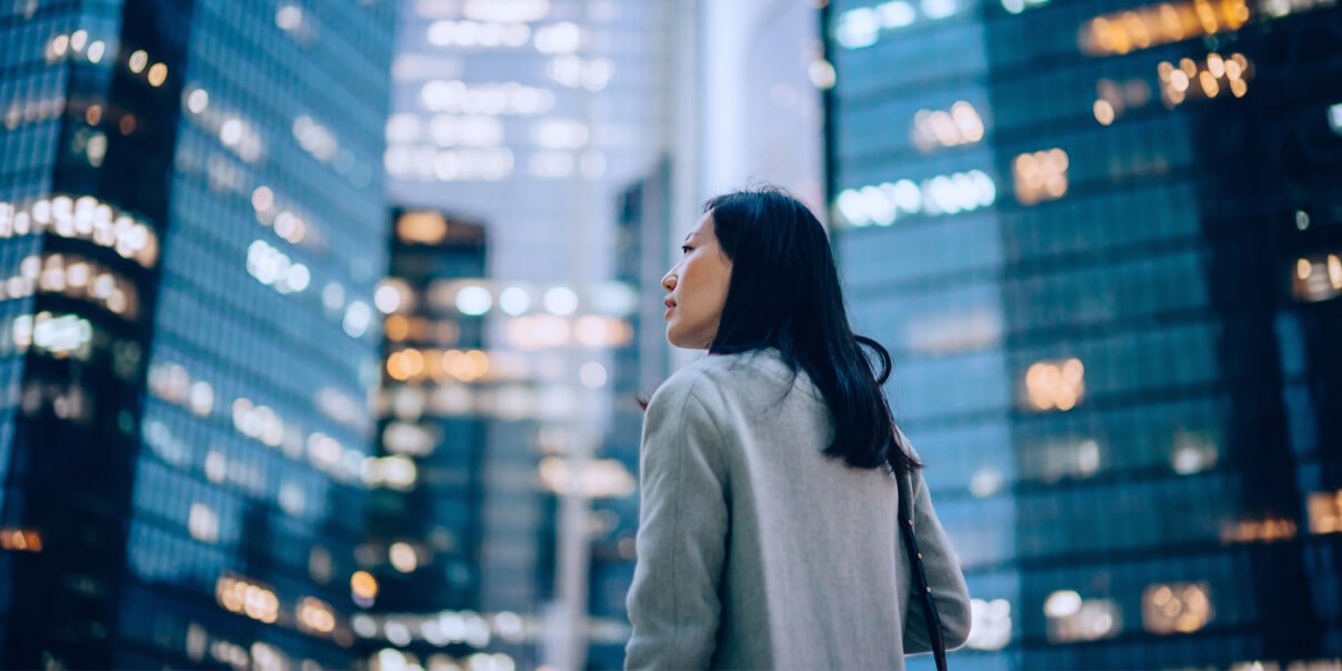 Woman surrounded by glass buildings