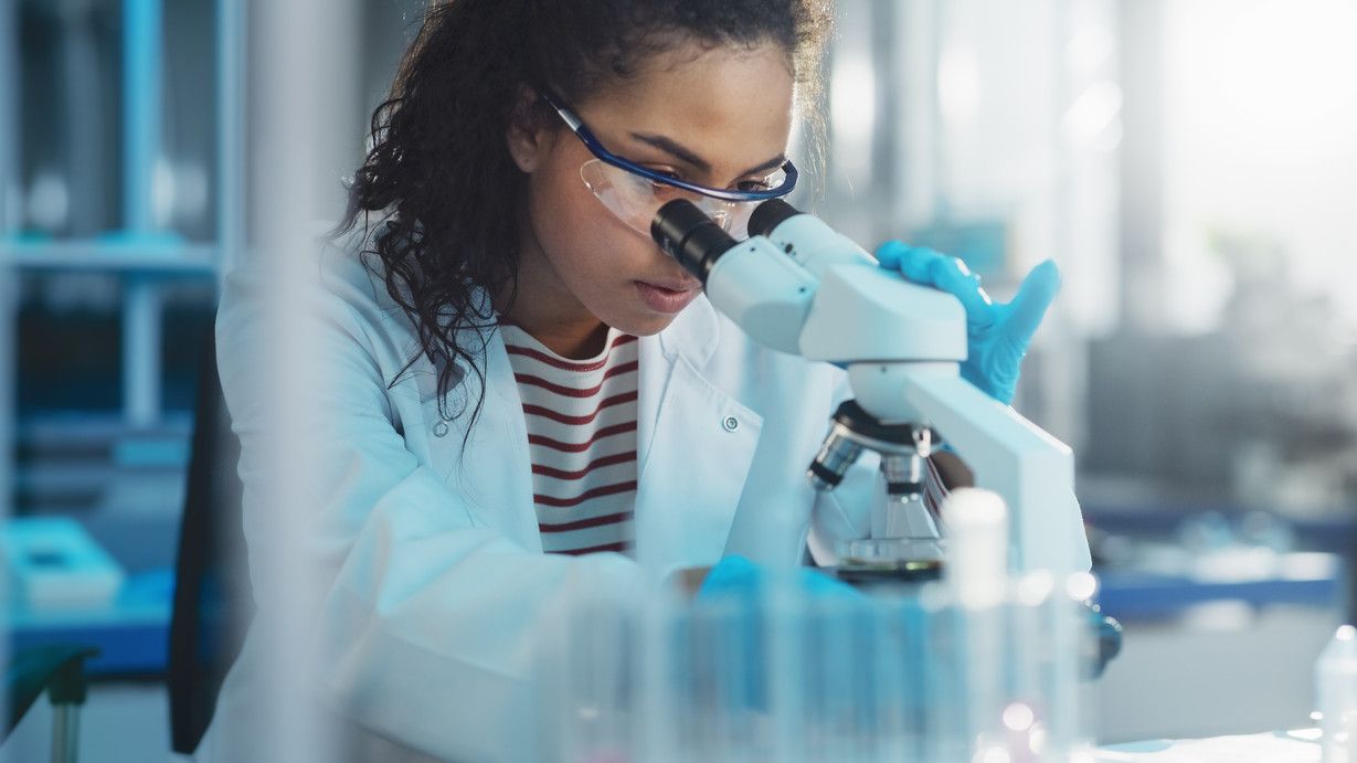 Medical Science Laboratory: Portrait of Beautiful Black Scientist Looking Under Microscope Does Analysis of Test Sample. Ambitious Young Biotechnology Specialist, working with Advanced Equipment; Shutterstock ID 1922200124; purchase_order: 680501-022; job: 680501; client: 680501; other: